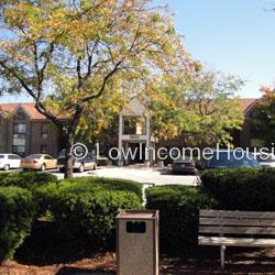 Photograph of townhouse entrance.  Building continues to left and right (large structure) Roof line can be seen bleeding off the page.