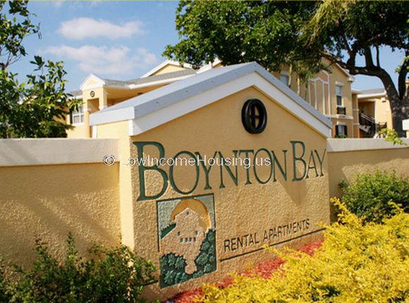 Entrance marker for Boynton Bay housing.  Wall is painted orange/yellow