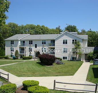 Photograph of large grey building with possiblely 19 to 20 rooms.