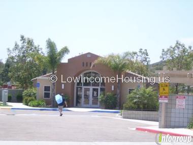 Outdoor picture of single story main office. Person walking and a slow sign. 