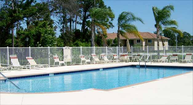 Large swimming pool with ample number of lawn chairs for sun bathing.