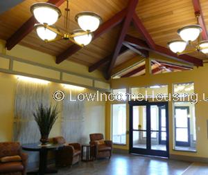 Interior view of entrance to apartment building equipped with ample lighting and two sets of double doors to exterior and interior. 