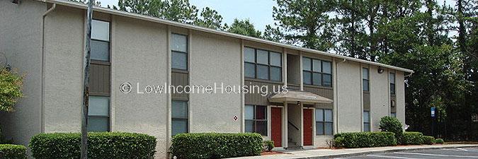 Large, two story row house building with single entrance, four large windows  