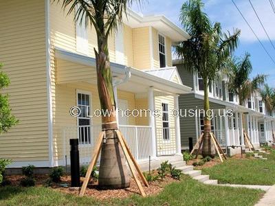 Wooden plank construction painted yellow. Each unit has large front door 