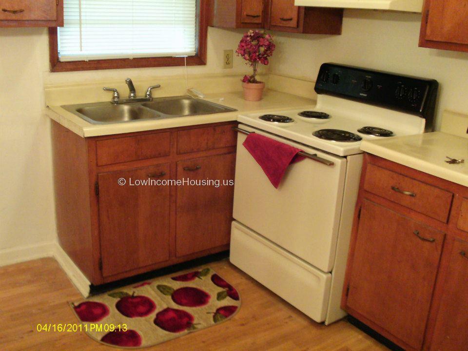 Photos of kitchen interior with four electric burners and oven Twin sink with Hot and Cold running water, ample cupboard storage space 