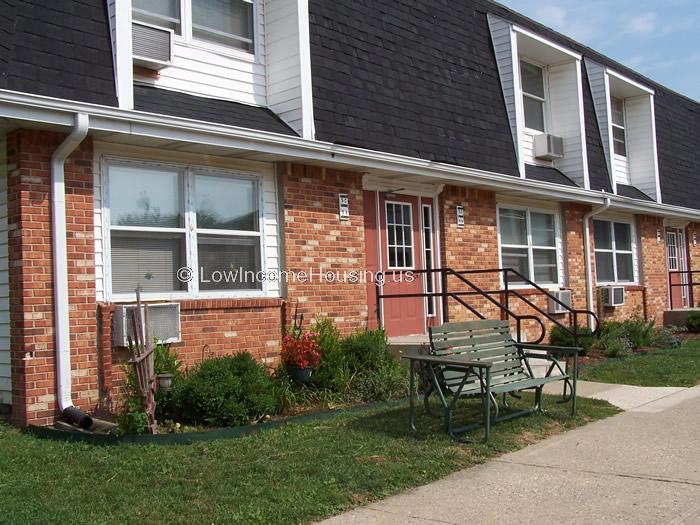 2 housing units with Red brick, large windows and air conditioners installed. 