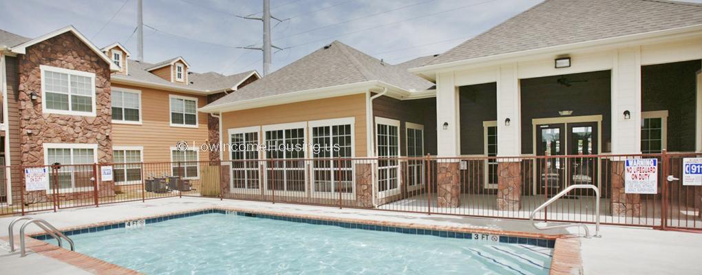 Enclosed swimming pool with wrought Iron  fencing enclosed within row houses with large picture windows 