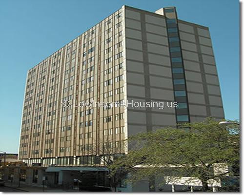 Very large, multi story building with six windows on the side of the building and 4 on the end of the building.   