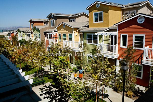 Elegant three story row houses with large picture windows, balconies with wrought iron fencing