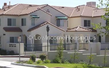 Beautiful two story town houses with wrought iron fencing second story windows with green canopies  