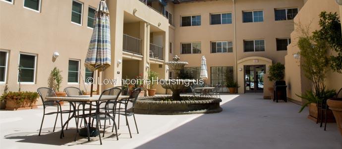 Spacious sun patio with fountains, outside wrought iron garden furniture.