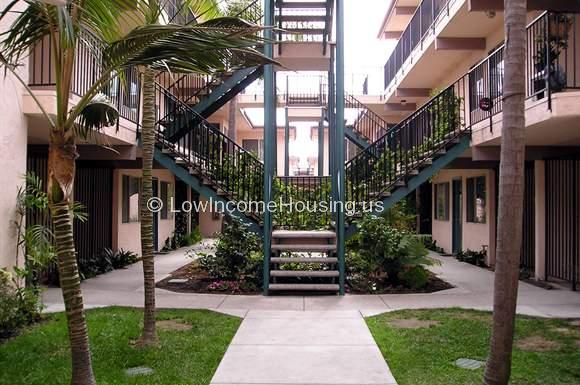 Ample row housing with spacious balconies, wrought iron railing and stair access to third level.