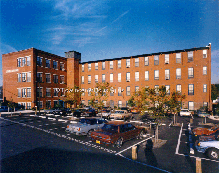 Classic large red brick apartment building with four levels, convenient curbside parking is  reserved available for residents 