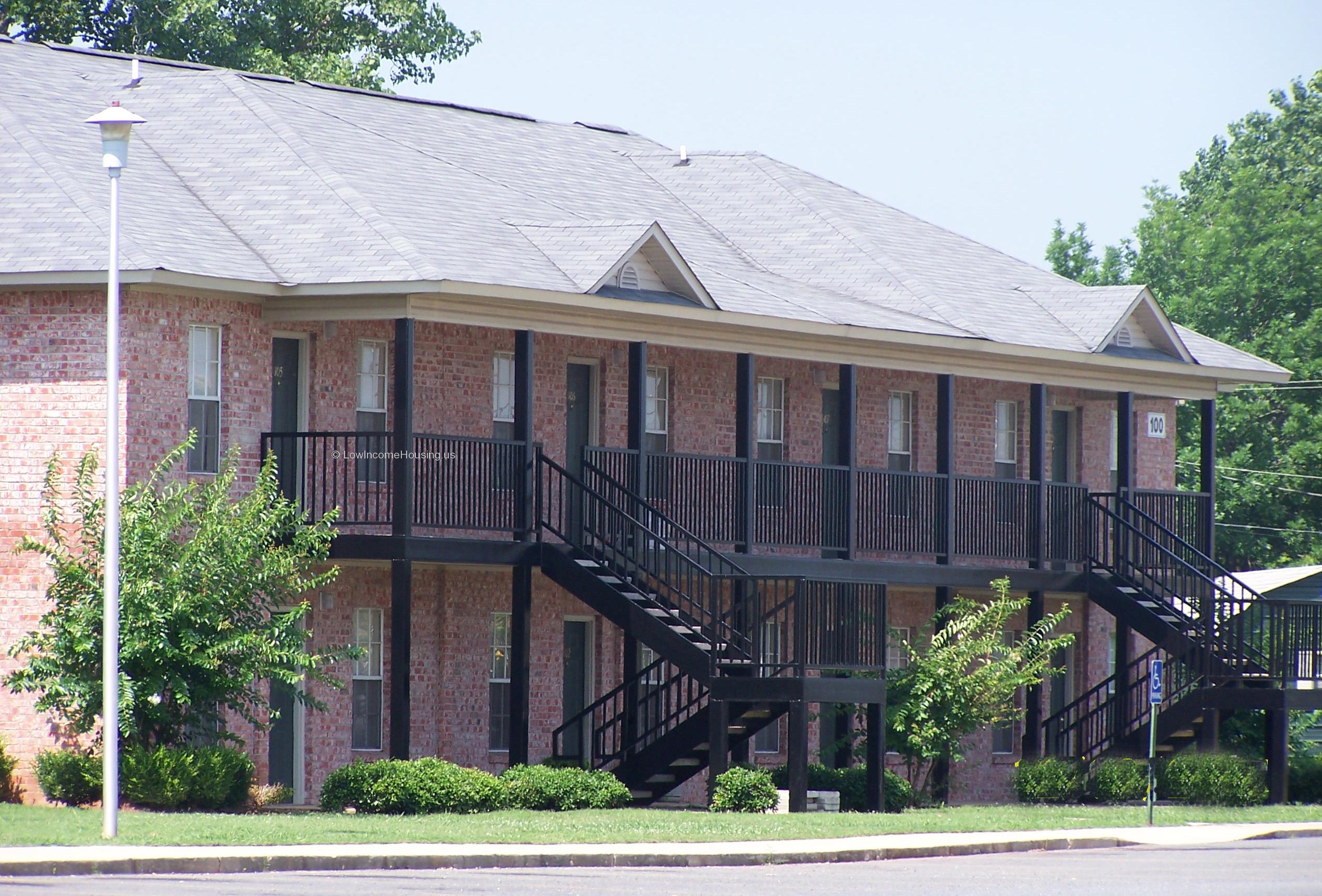 Classic red brick unit construction with floor to ceiling screened windows, wrought iron stairway to second level and attic breather  air ventilation unit.