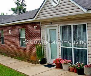 Classic red brick row house with floor to ceiling access door and twin floor to ceiling windows provide ample lighting with convenient access to the outside. 