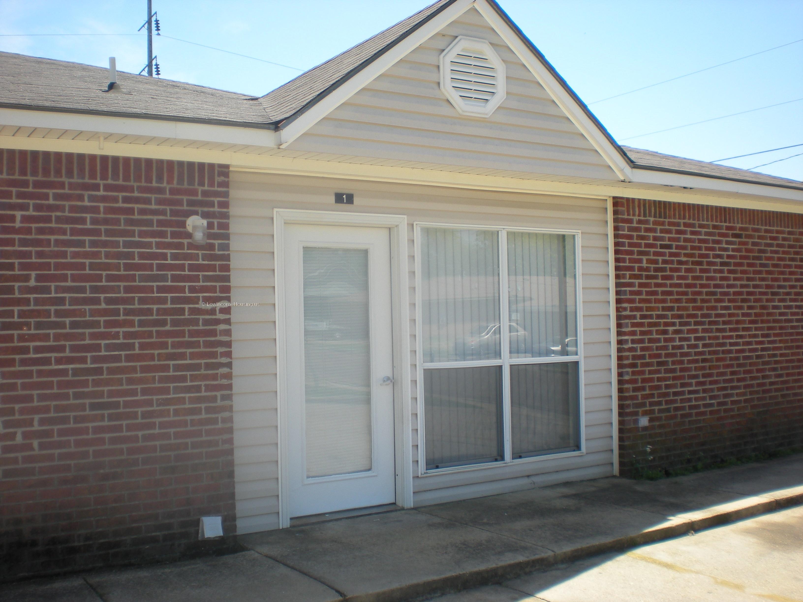 Classic red brick row house with full height door, full height floor to ceiling twin windows. 