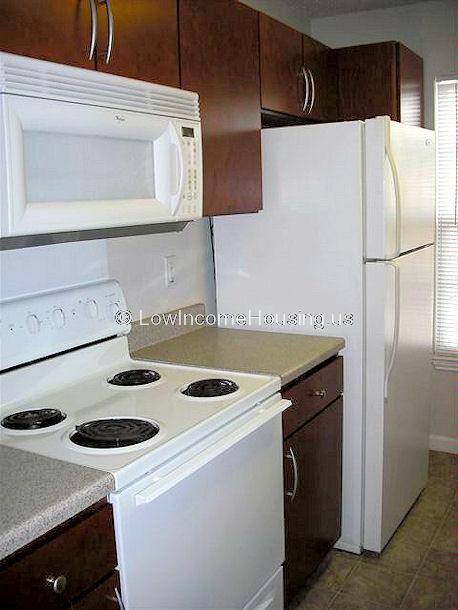 Interior detail of kitchen equipped with electric burners, refrigerator/freezer overhead exhaust unit, Microwave and oven. 