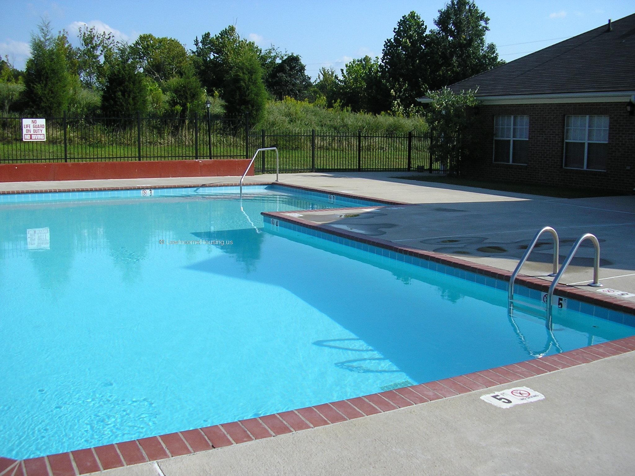 large swimming pool with wrought iron fencing.