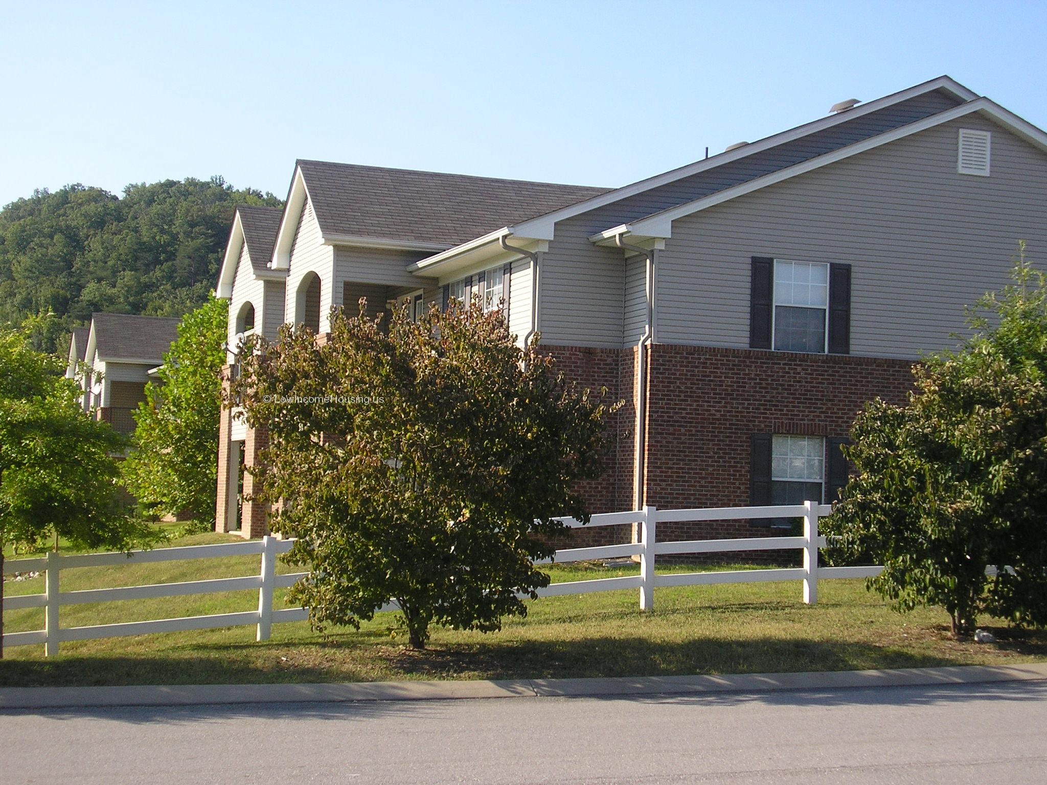 Classic red brick housing unit with spacious dormer windows and twin balconies.  