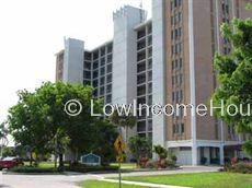 Three story classic red brick apartment complex with storm-proof window frames and ample curbside parking 