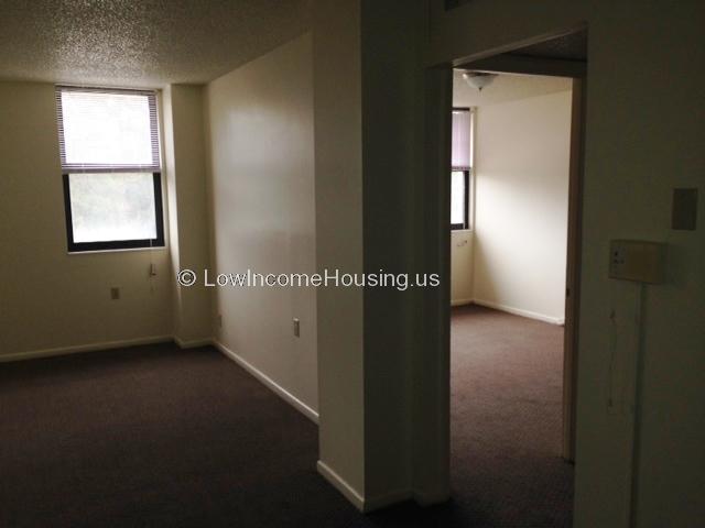 Interior view of two room apartment with large windows.