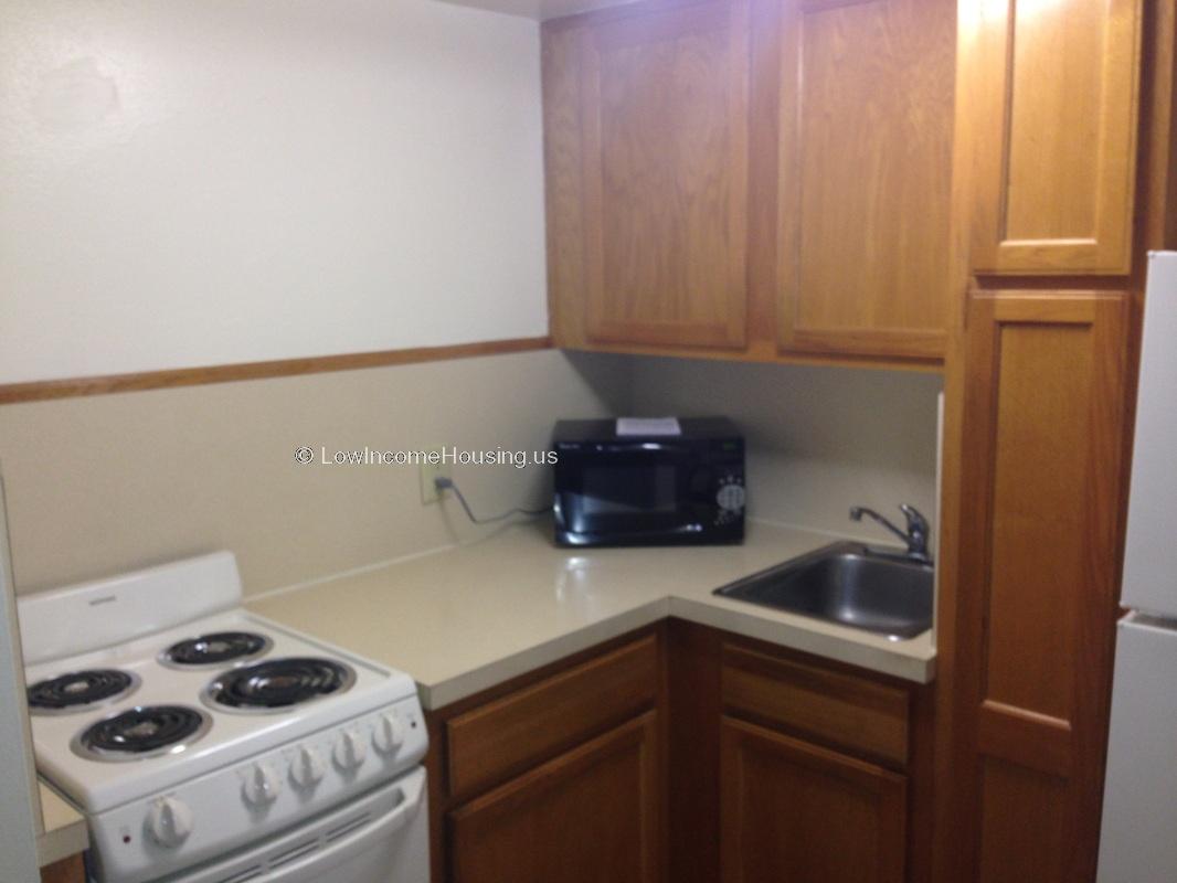 Photograph of apartment kitchen, stove with four burners, oven, ample supply of closet an drawer space.