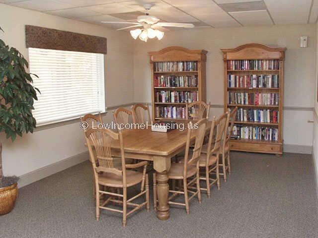 Large wooden table with 8 wooden chairs, two book cases filled with books