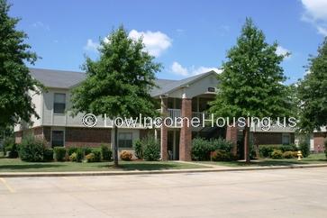 street view picture of two story building and four large trees