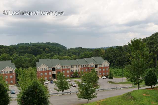 Arial view of classic red brick housing unit equipped with 3, 2, 2, 3 apartments with installed air conditioners and ample curbside parking 