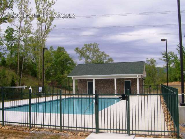 Large swimming pool with wrought iron fencing and male/female toilet facilities and exterior lighting.