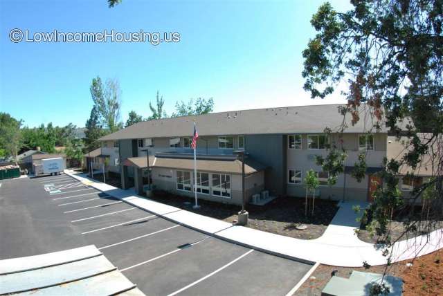 Large living unit space using red brick with ample window area and views of picturesque mountain terrain.  