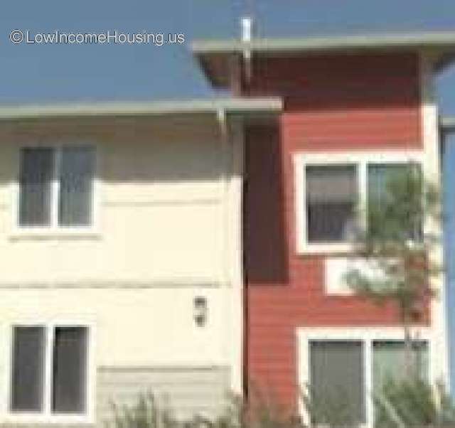 Photograph of two housing units.  White building with two floors and Red building with two floors and large windows.