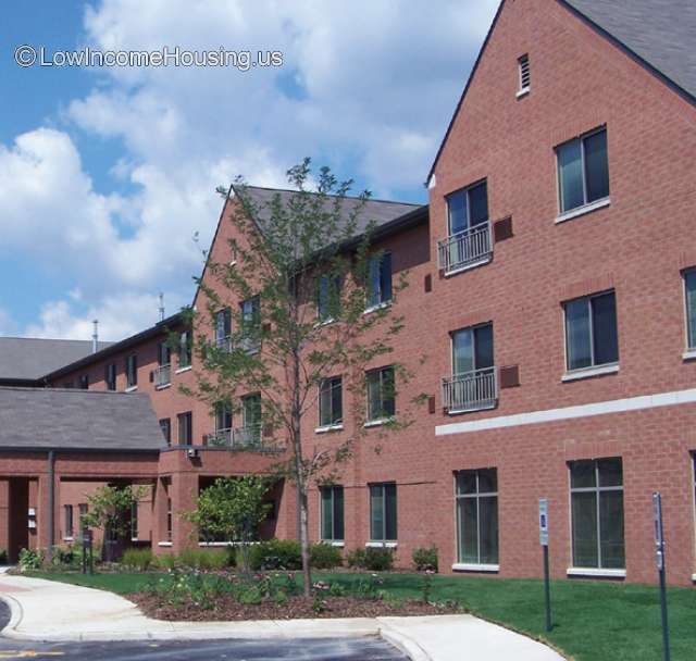 Bright red brick construction with covered entrance way give access to three twin story construction with floor to ceiling window units 