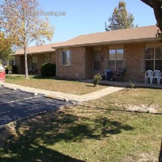 Red brick housing with shaded nich with lawn chairs