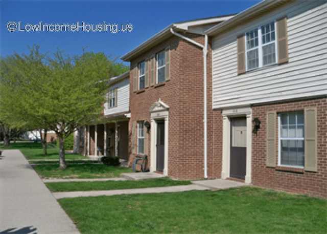 Simple red brick construction with wooden clapboard painted white.