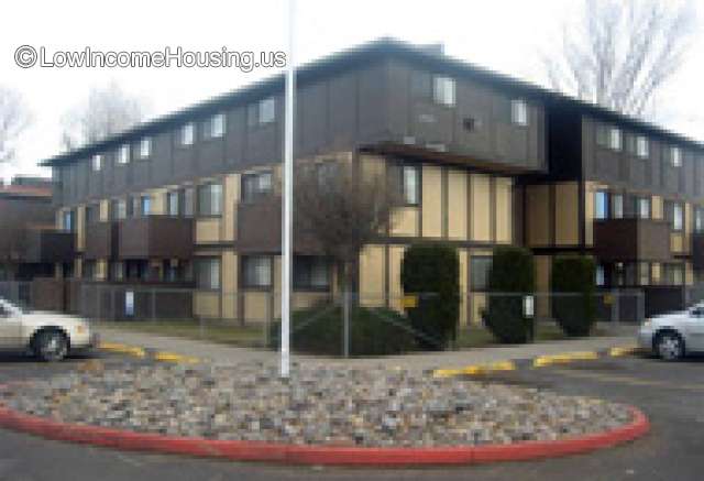 Corner Photo of large, three story masonry structure with access to on-site parking, dormer windows and exterior balcony.