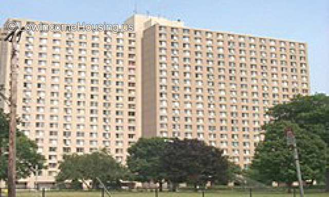 Over 15 story huge 2 block apartment building complex. Park in the front with trees. 