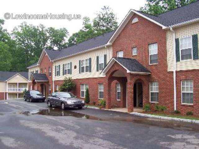 This photograph shows the entrances to two offices.  There are two cars parked outside. 