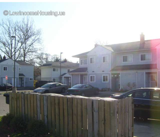 Wooden multi story town houses with ample windows installed and resident parking. 