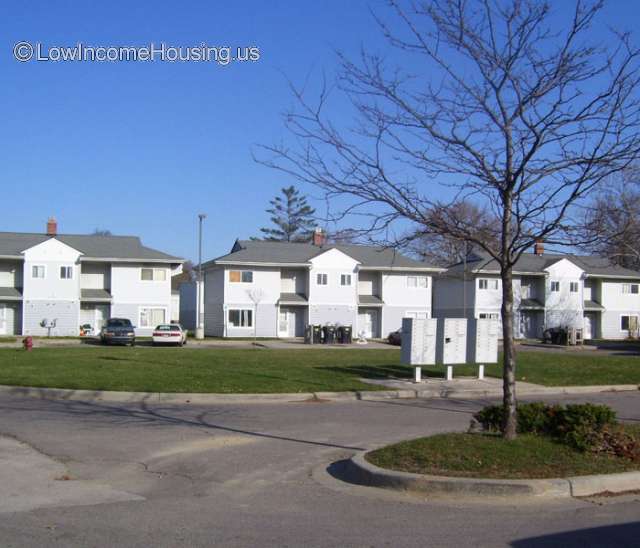 Photograph of White, two story Clapboard structures and 6 rooms per unit with shared access to street.  