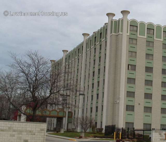 large concrete structure with eight floors and awning out to parking. 