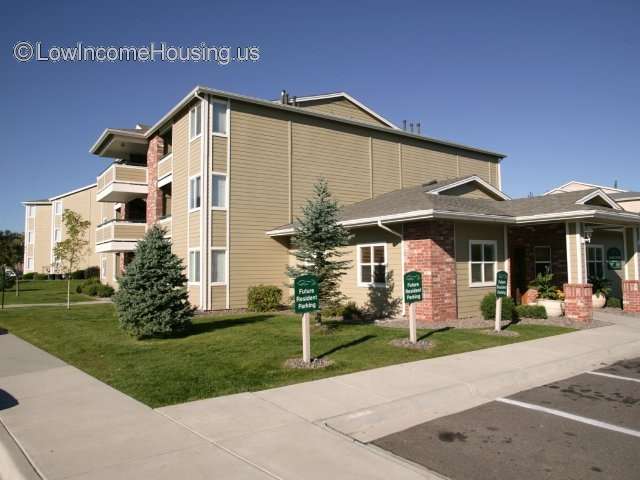 Large three story building with corner windows and projecting balconies over entrances 