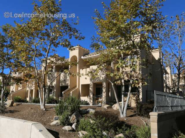 Streetview picture of a two story building. There are trees in the front and two staircase access entrances.